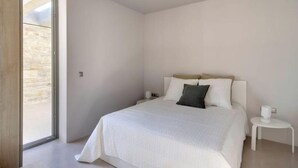 Una camera da letto con un letto, un comodino e una finestra.