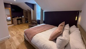 A bedroom with a large bed, a desk, a chair, and a small closet. - Auberge (Lytham St. Anne's)