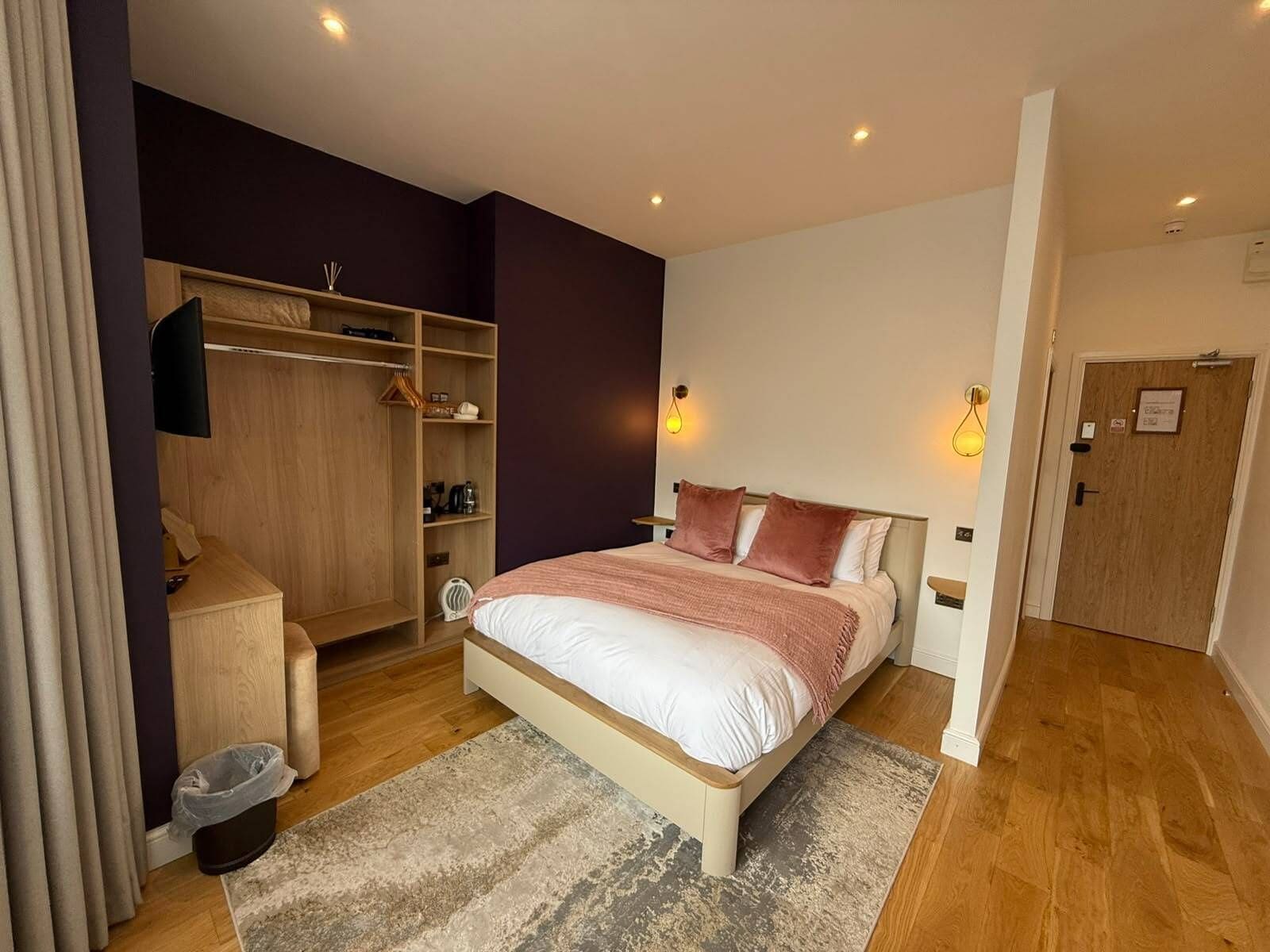 Une chambre à coucher avec un lit, une armoire, un bureau et une porte.