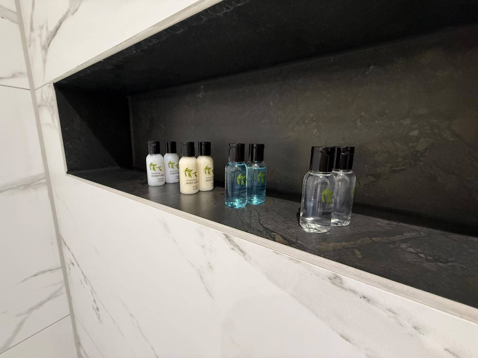 A bathroom shelf with various toiletries.