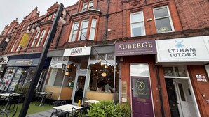 A row of buildings with storefronts, including a hotel, a luxury accommodation, and a tutoring service. - Auberge (Lytham St. Anne's)