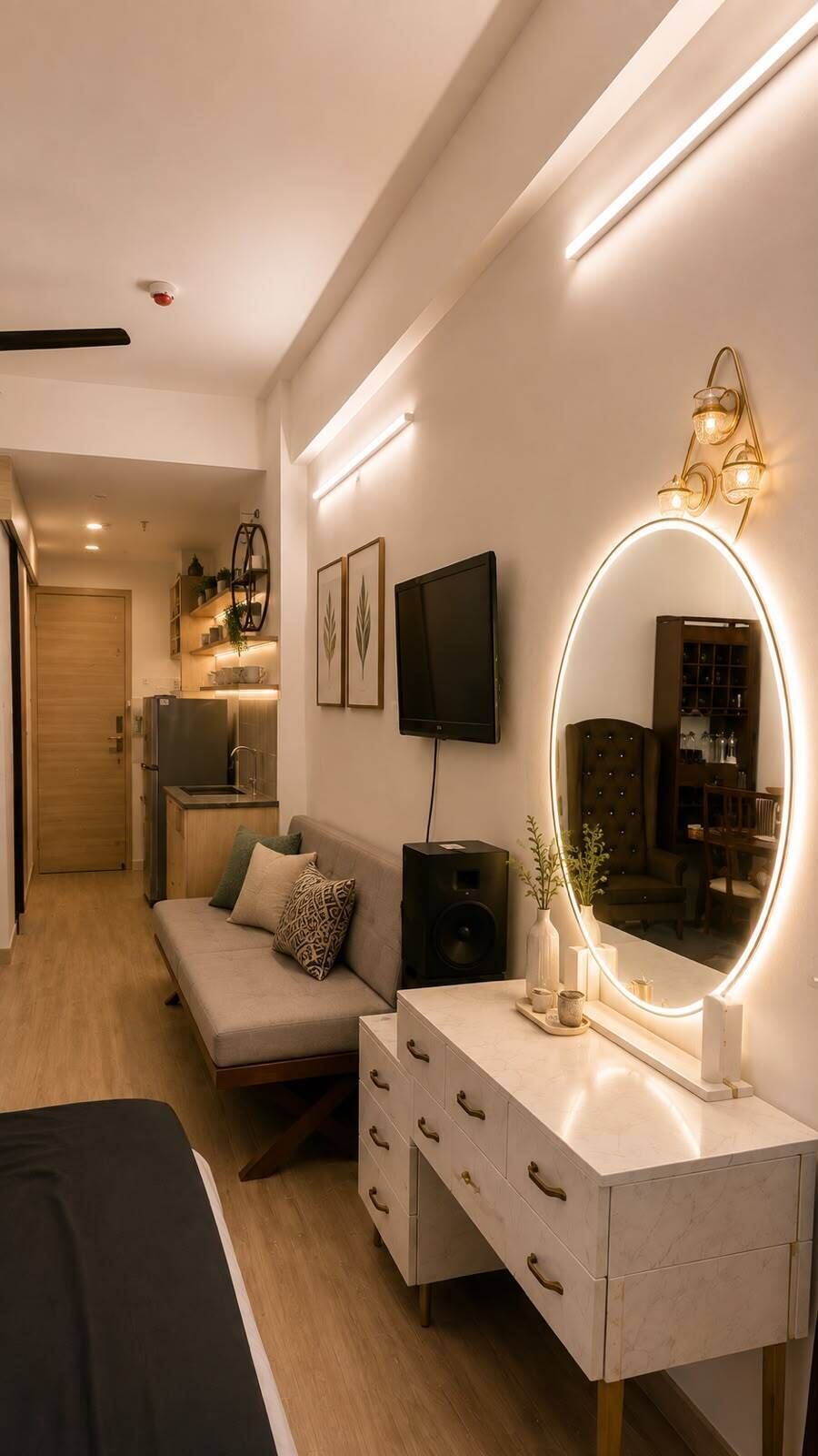 A modern bedroom with a bed, a bedside table with a mirror, a TV, and a sofa.