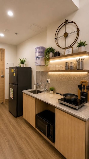 A modern kitchen with a built-in stove, a sink, and a refrigerator. - Diamond Villa (Gautam Buddh Nagar)