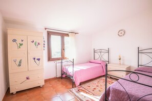A bedroom with a bed, a dresser, a window, and a radiator. - Alloggio turistico Isola dei Cavalli (Manziana)
