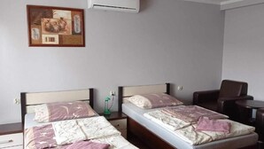 Una camera d'albergo con due letti, un tavolino e una sedia.