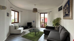Una sala de estar moderna con un sofá, una mesa de centro, un televisor y una planta.