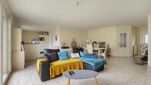 Un salon comprenant un canapé, une table basse et un coin repas avec une table et des chaises.