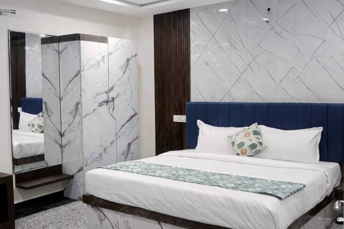 A modern bedroom with a bed, a mirror, and a ceiling fan.