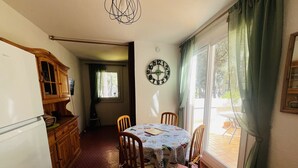 Ein Essbereich mit Tisch, Stühlen, einer Uhr und Blick durch ein Fenster.
