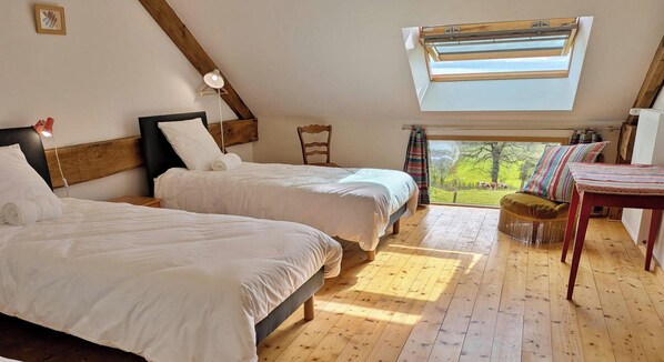 A bedroom with two beds, a window, and a view of the outdoors.