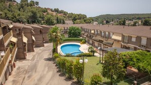 A residential area with a swimming pool, multiple-story buildings, and surrounding greenery. - House in La Mora - 8 guests (Tarragona)