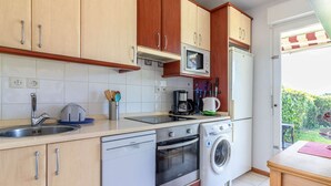 Una cocina compacta equipada con lavavajillas, horno, microondas y cafetera.