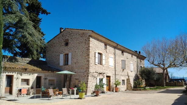 A stone building with a courtyard, outdoor seating, and potted plants. - LE MAS GORCE, Drôme valley, spacious TERRACE, courtyard, parking, garage. (Chabrillan)