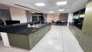A modern kitchen with a central island, built-in appliances, and a dining area with a table and chairs. - Adorable 1-BD apartment with very unique location in Dubai down town (Dubai)