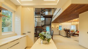 A modern interior with a kitchen, dining area, staircase, and living room. - ELIVAAS privé Royce Rose 4BHK Hilltop (Kasauli)
