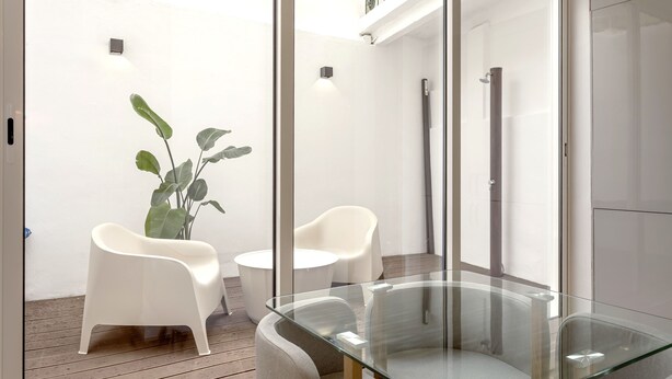 A modern bathroom with a glass shower enclosure, white chairs, and a glass table. - GRA A Terrace by Homing (Lisbon)