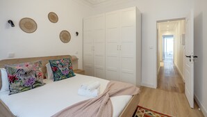 A bedroom with a bed, pillows, a wardrobe, and a hallway. - GRA A Terrace by Homing (Lisbon)