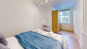 Una camera da letto con un letto, una scrivania con uno specchio e una finestra.