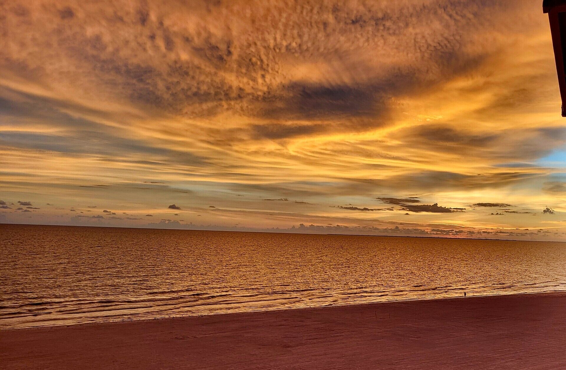 Ein Strand mit Sonnenuntergang und klarem Himmel.