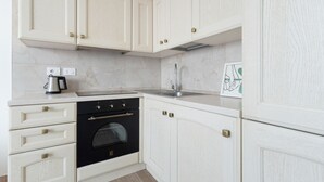 A kitchen with white cabinetry, a black oven, a stainless steel sink, and a coffee maker. - Cozy 50m2 apartment, perfect for 4 people, located on the 5th floor of a building with lift just 500m from Parco Nord, the largest green area in Milan!At 500m there is the Bruzzano-Parco Nord stop of the S2/S4 suburban train which in just a few stops t (Milan)