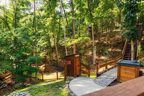 Eine Holzterrasse mit einer kleinen Holzhütte, einer Treppe und einem Metallgeländer.