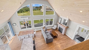 A spacious loft with a large dining area, a cozy seating area, and a fireplace.