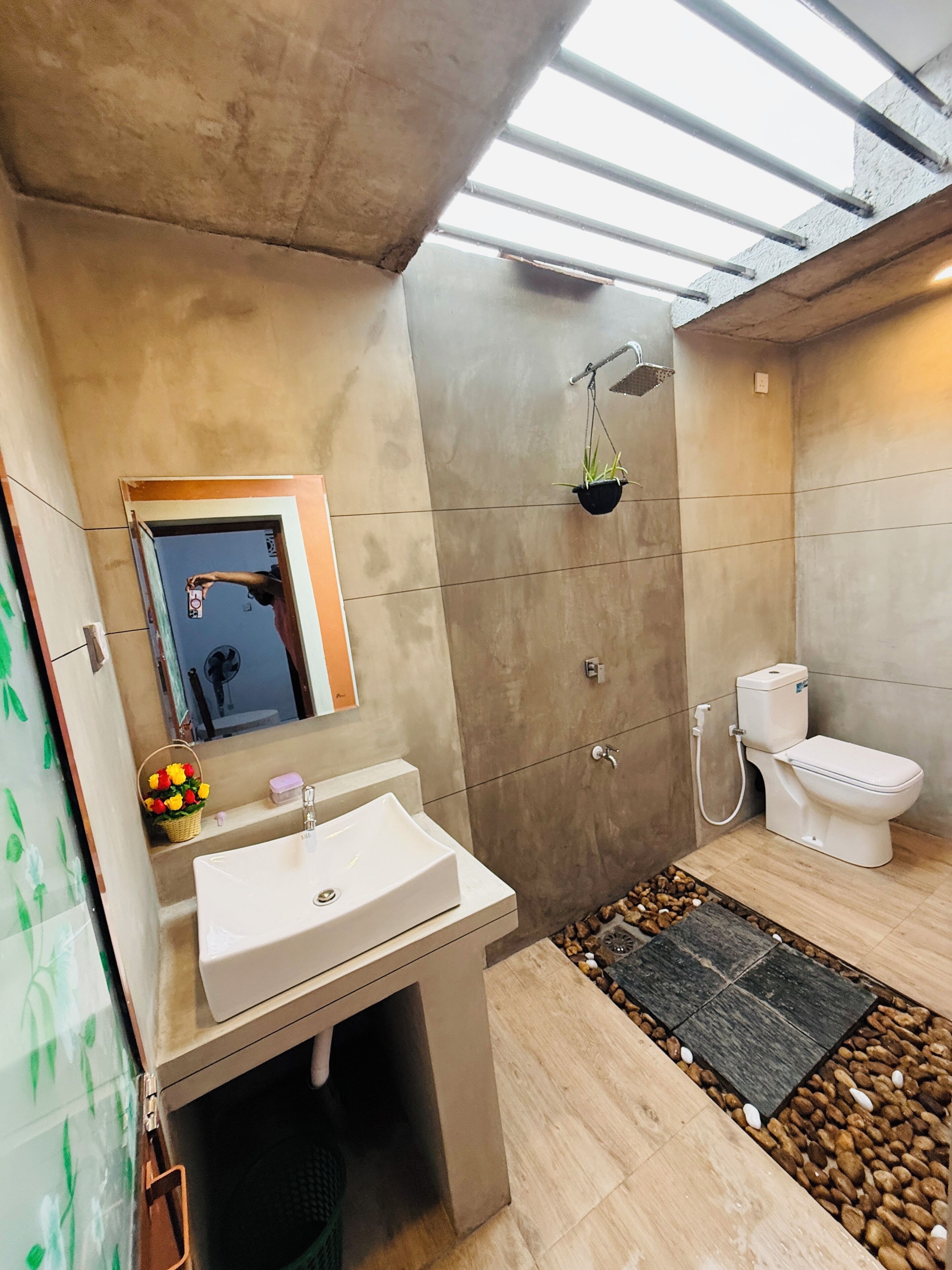 Une salle de bain moderne équipée d’un lavabo, de toilettes et d’une douche.