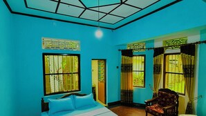 A room with a bed, a chair, a table, and a ceiling with a geometric design. - Freedom River House (Ahangama)