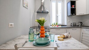 A kitchen with a marble countertop, a vase with flowers, a toaster, and a bread roll on the table. - Italianway Easy - Buenos Aires 2 A (Milan)