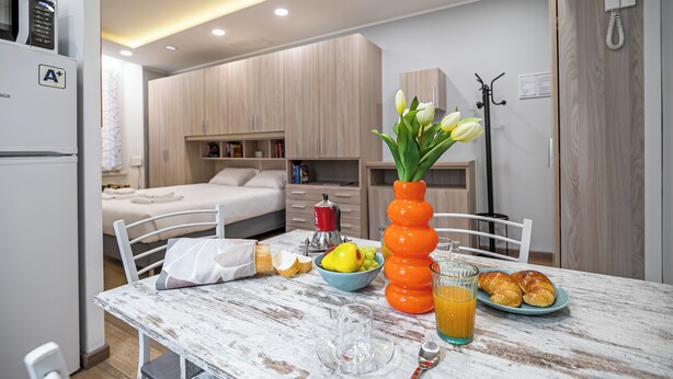 A compact kitchen with a dining table, a bed, and a kitchenette. - Italianway Easy - Buenos Aires 2 A (Milan)