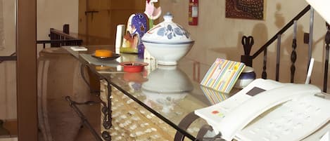 A kitchen with a wooden table, a white telephone, and a vase with flowers.
