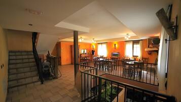 Un grand espace de vie comprenant un coin repas avec une table et des chaises, ainsi qu’une cuisine équipée d’une cuisinière et d’un évier.