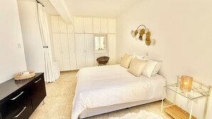 Una camera da letto con un letto, una cassettiera, una toeletta, una sedia e un armadio.