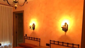 Une chambre d’hôtel avec deux lits, une table de chevet, un luminaire fixé au mur et une porte.