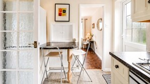 Una cocina moderna con comedor, un radiador y una ventana con vistas.