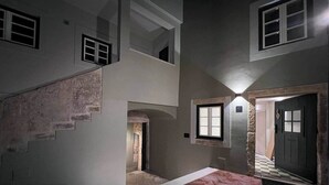 Ein mehrgeschossiges Interieur mit Treppe, Tür und Fenster.