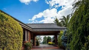 A covered entrance to a building with a paved driveway. - Oak Hill Grand Country Escape with Sunset Views (Chirnside Park)