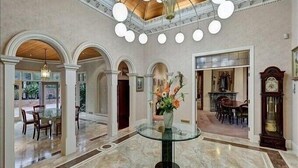 A spacious lobby with a glass coffee table, marble flooring, and a chandelier. - Oak Hill Estate - Main House plus Cottage (Chirnside Park)