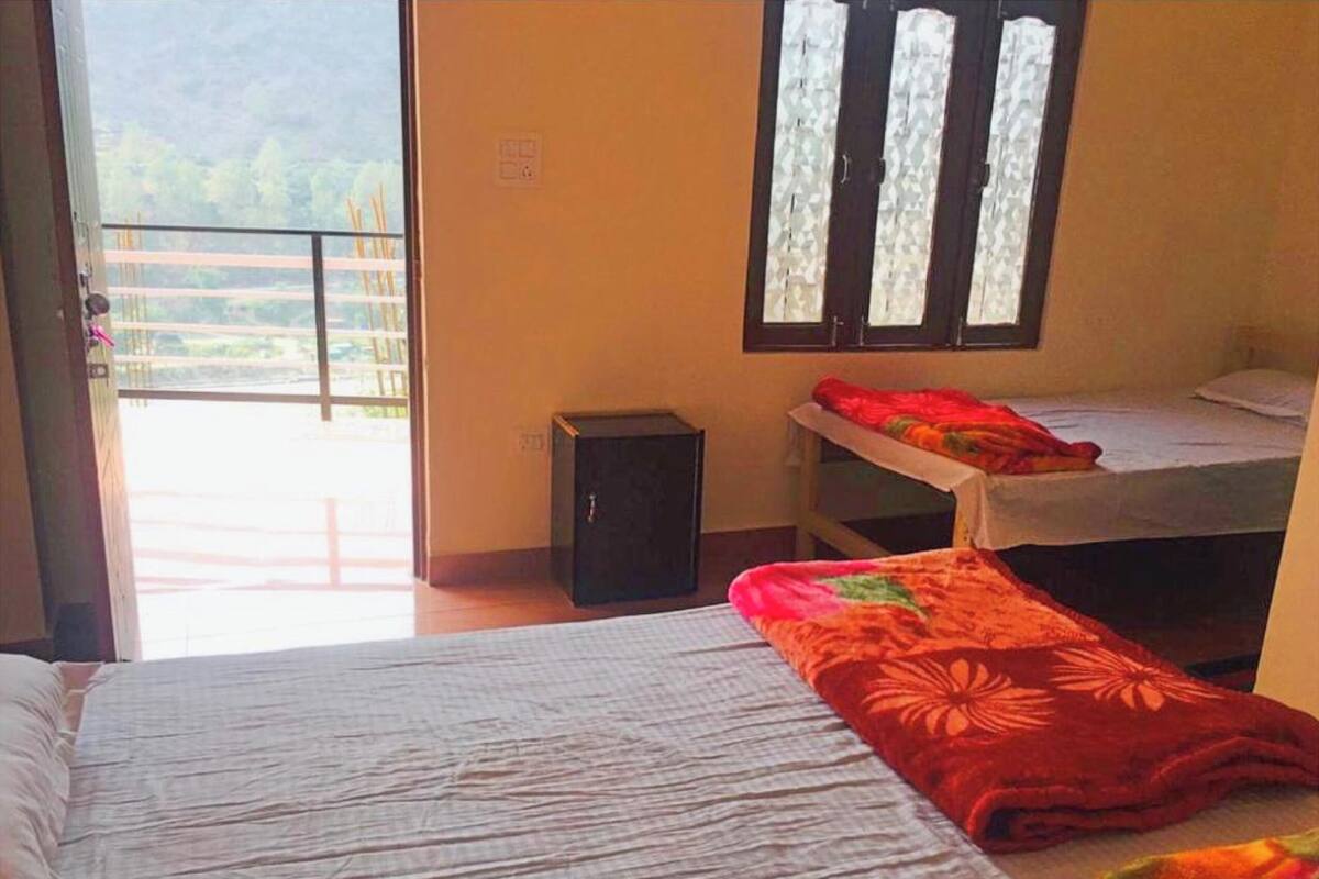 A room with a bed, a small table, and a window with frosted glass.