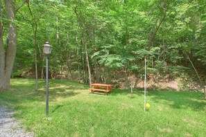 Uma mesa para piquenique em área arborizada com um poste de luz por perto.