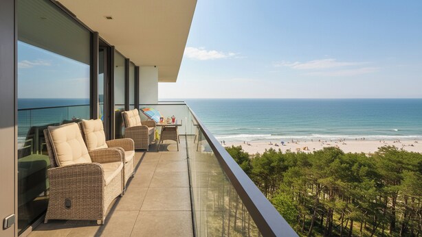 Un balcone con mobili in vimini, un tavolo e sedie con vista sulla spiaggia.