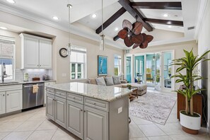 A spacious kitchen with white cabinets, a central island, and a ceiling fan. - Mangrove Walk-30+ Day Rental in Harbour Isle in Perico (Bradenton)