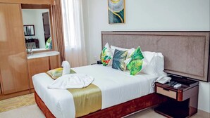 Une chambre d’hôtel avec un lit, une table de chevet, un téléphone et un miroir.