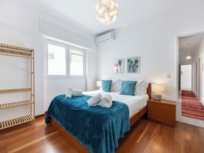 A modern bedroom with a bed, a wooden shelf, a window, and a hallway. - Casa Sardinha - in the heart of Portimão (Portimão)