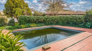 A rectangular swimming pool with a paved edge, surrounded by a variety of greenery and a hedge. - Country House - Isola dei Cavalli (Manziana)