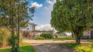 A building with a covered porch, a gravel path, and surrounding greenery. - Country House - Isola dei Cavalli (Manziana)