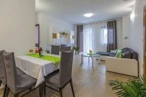 Ein modernes Wohnzimmer mit Essbereich, einer Couch und einem kleinen Tisch.