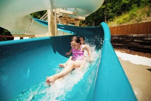 A water slide with a person at the bottom, surrounded by water.