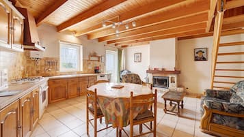 A spacious kitchen with wooden cabinets, a dining table, and a fireplace.