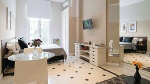 A modern hotel room with a bed, a round table, a TV, and a mirror. - LDV Aparts 2E by MOT Rentals (Buenos Aires)